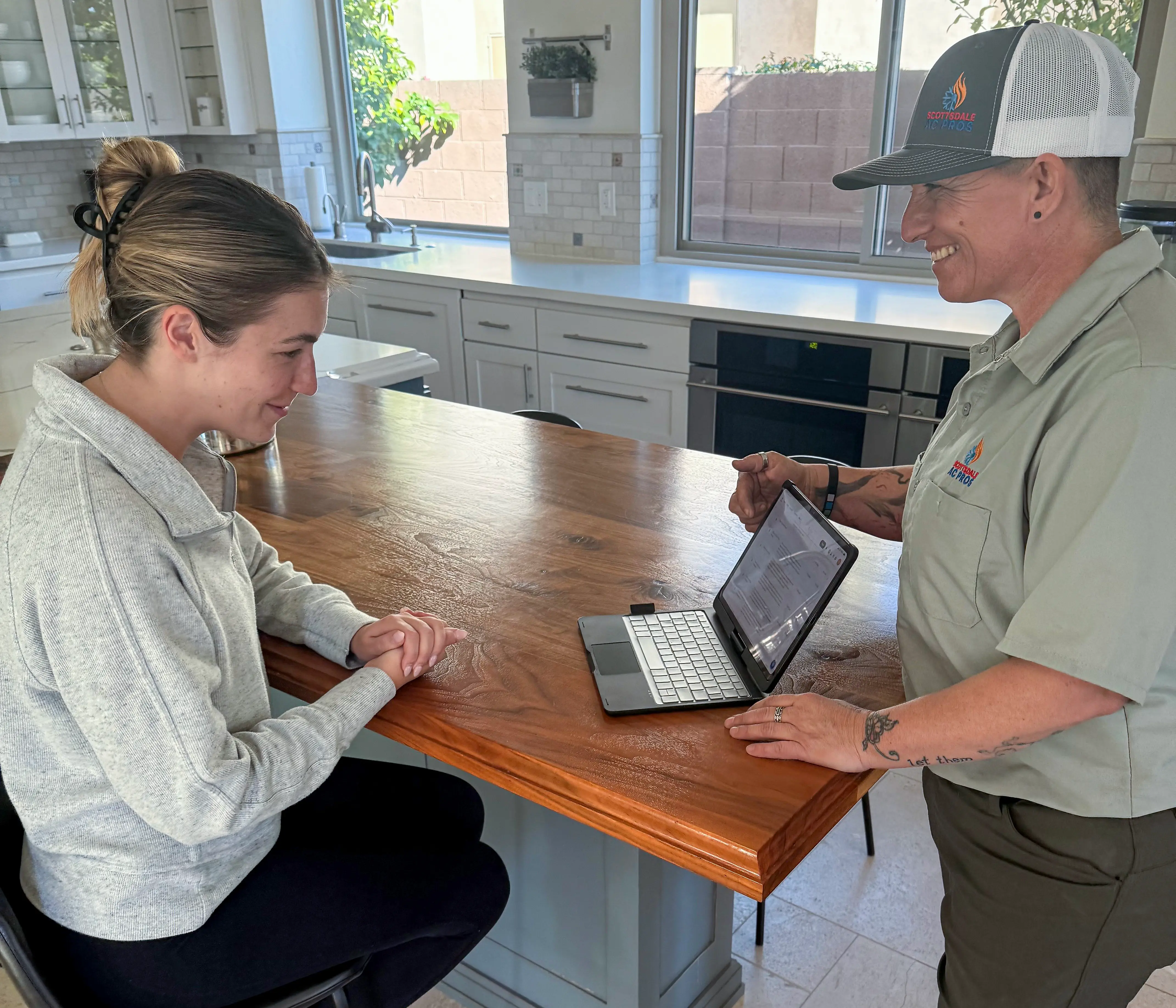 Technician discussing HVAC options with a homeowner in their kitchen